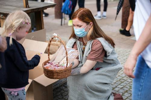 Zdjęcie przedstawia wydarzenie zorganizowane z okazji Dnia Dziecka w 2021 roku. Na zdjęciu widać animatorów oraz dzieci w parku w centrum miasta Pruszcz Gdański.